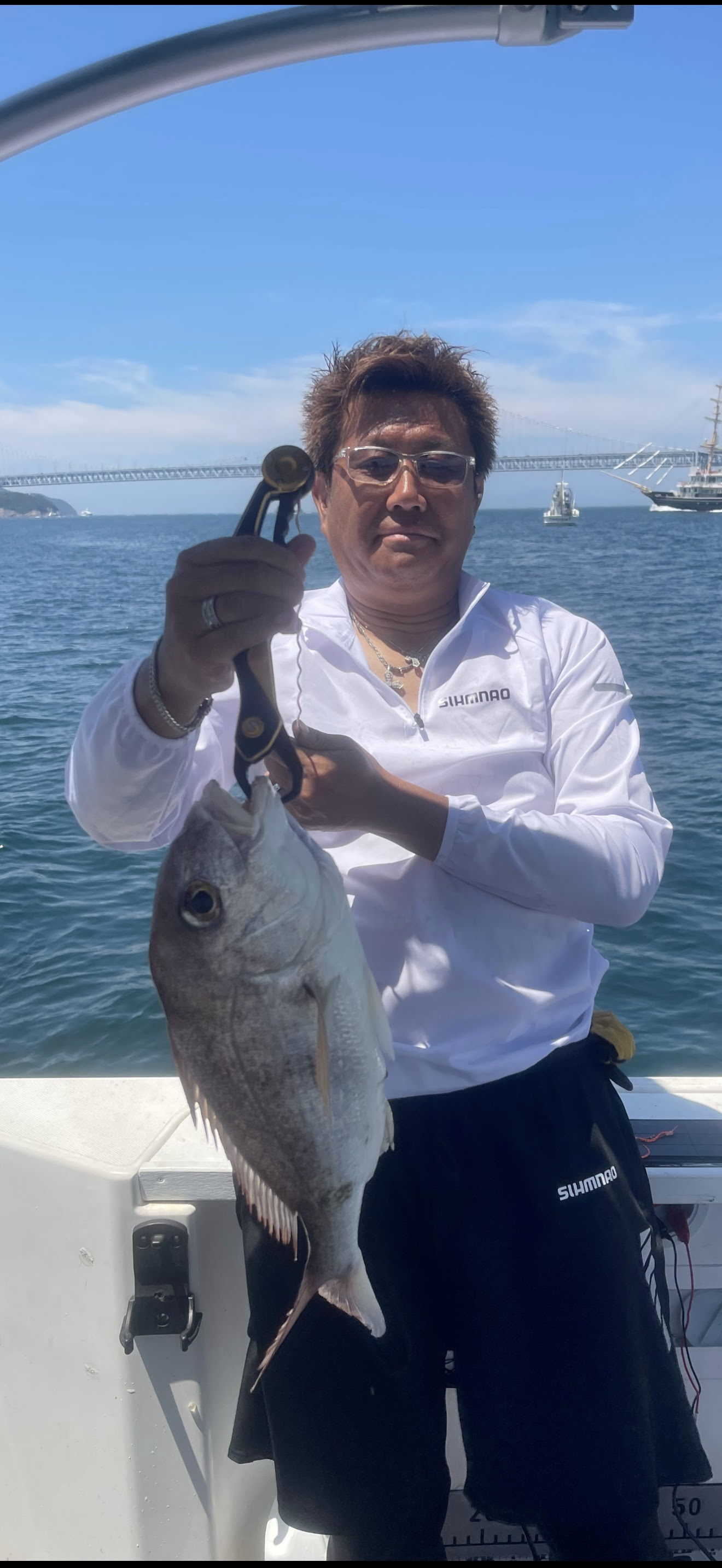 船上で魚を持つ写真