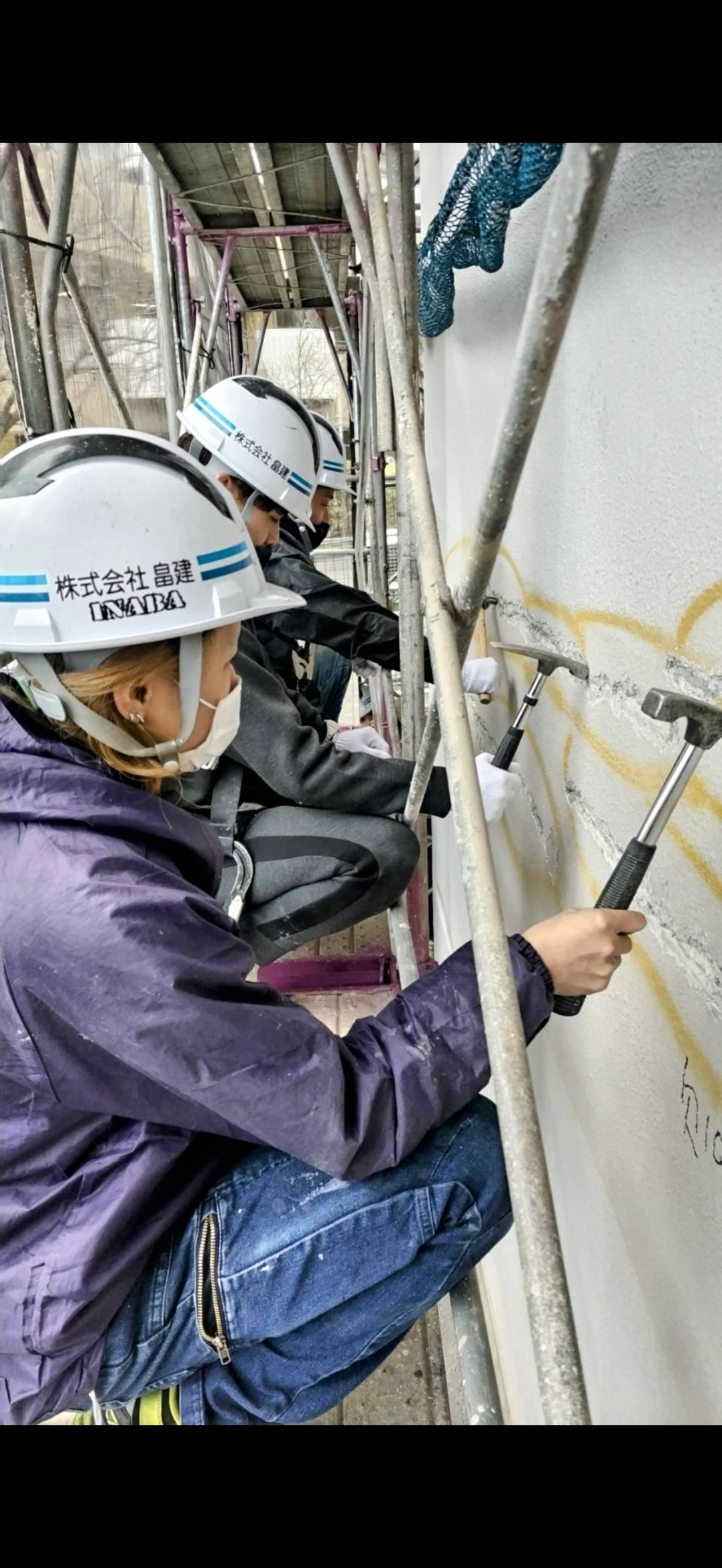 足場上で複数名が作業する写真
